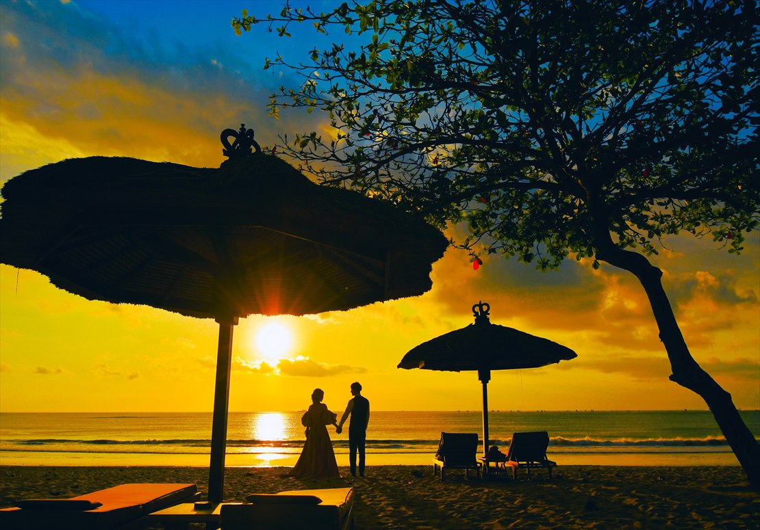 空と海が夕日に染まる風景を水平線まで望む