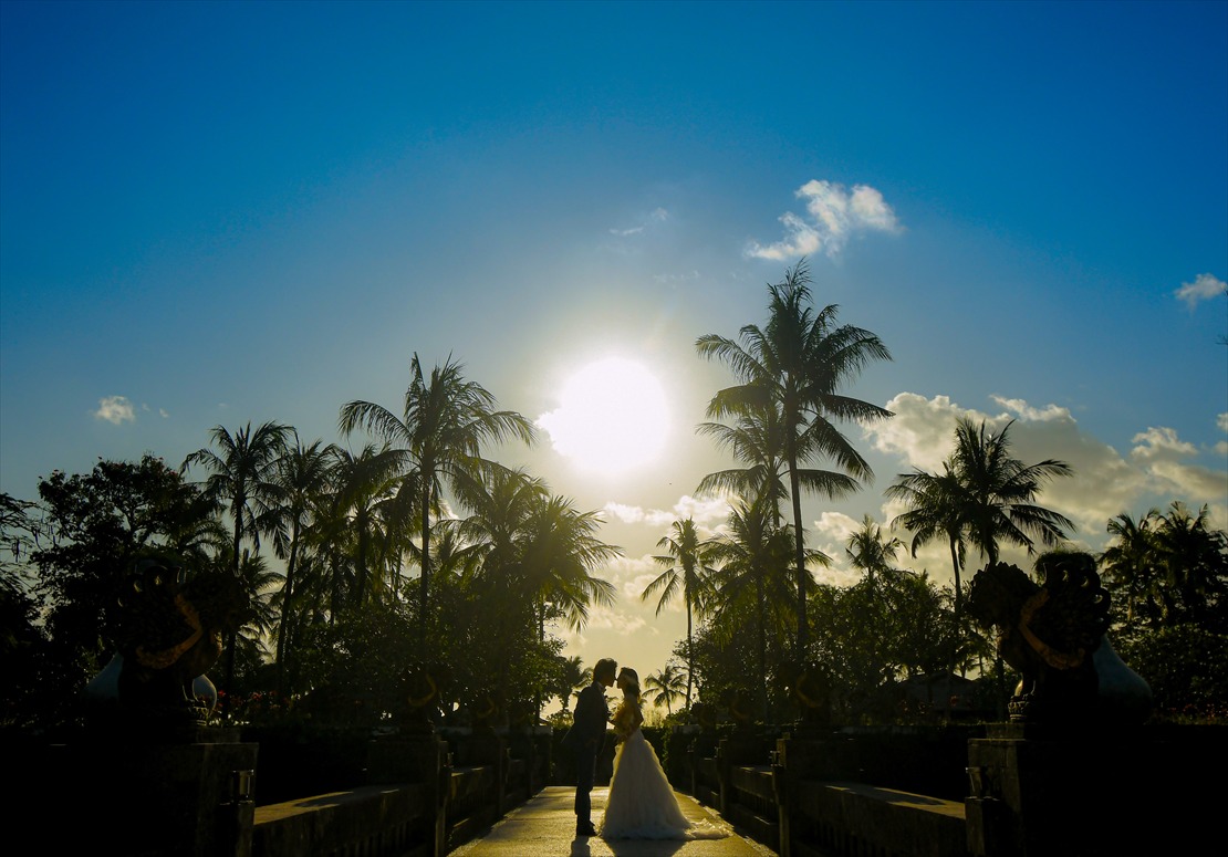 正面に夕日を望む石像が立ち並ぶブリッジ